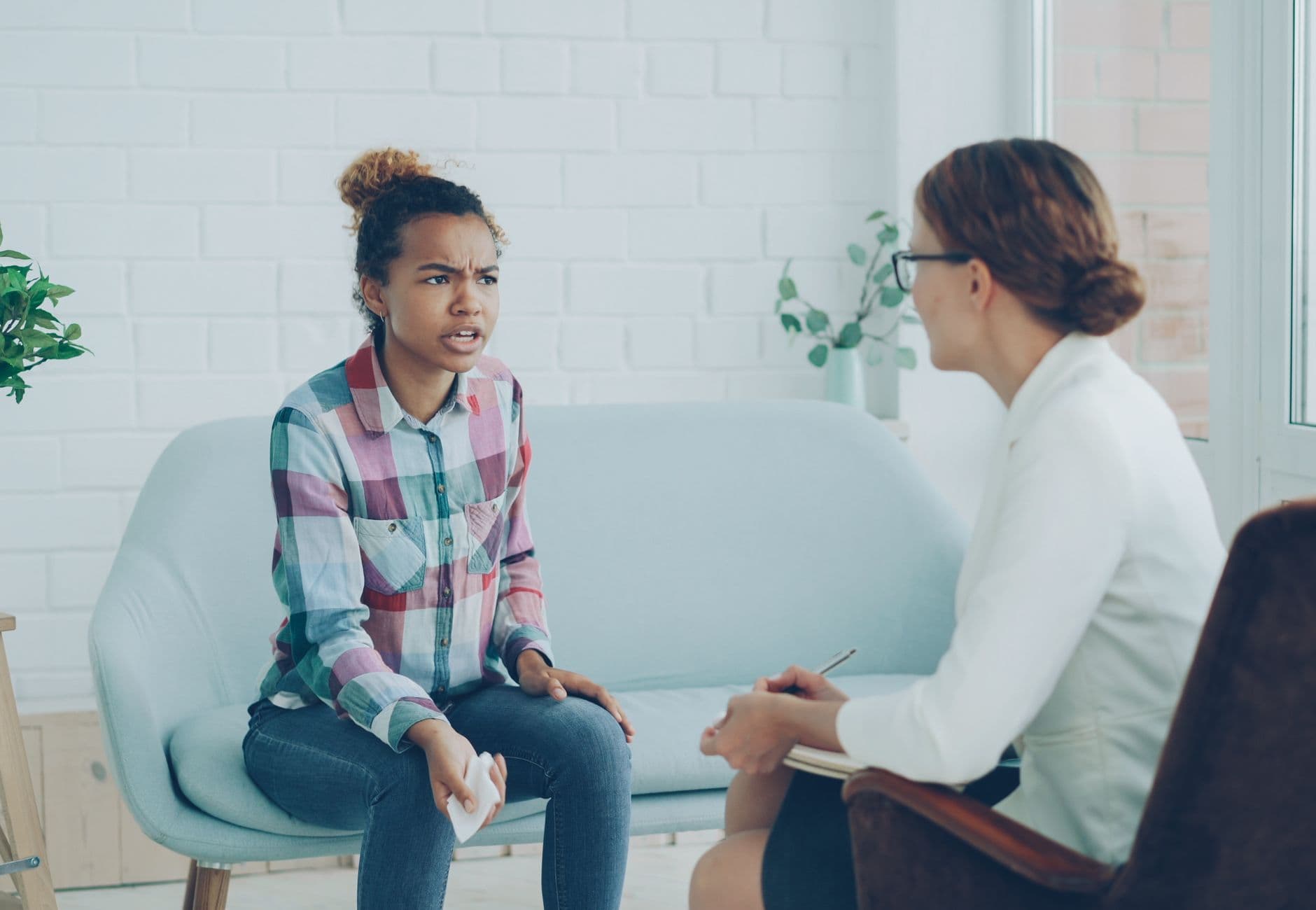 Therapist and patient in conversation during a counseling session indoors.